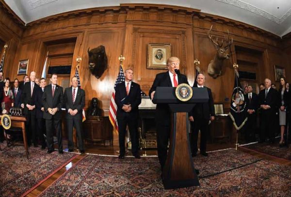 PRESIDENT DONALD TRUMP FLANKED BY SECRETARY OF THE INTERIOR RYAN ZINKE AND VICE PRESIDENT MIKE PENCE WHILE SIGNING THE ANTIQUITIES ACT EXECUTIVE ORDER ON APRIL 26. pHOTO BY